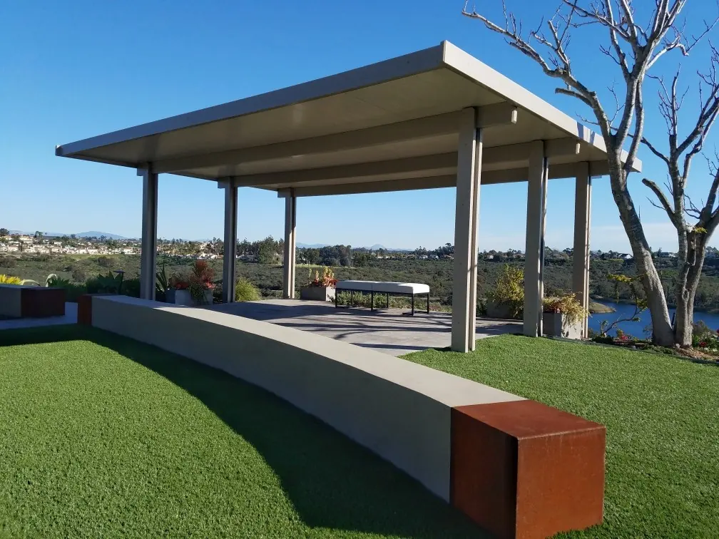 Freestanding solid patio cover on a lawn with a valley view