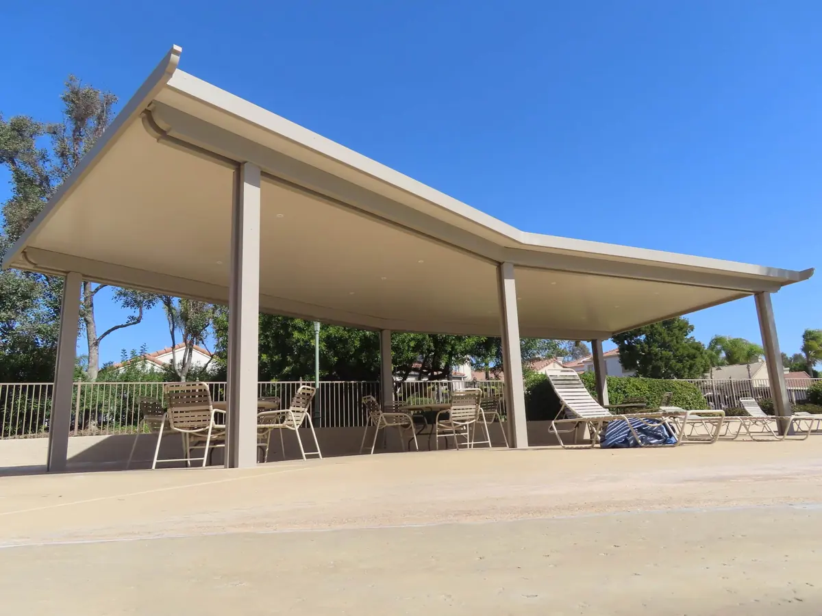Wide solid patio cover with a curved roof edge over a concrete patio